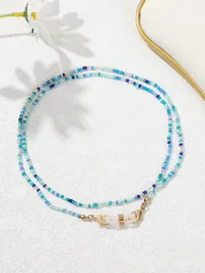 Makroansicht der blauen und cyanfarbenen Perlenkette für Brillen oder Masken, handgefertigt.
