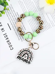 Detailed view of leopard print silicone bead wristlet keychain with rainbow mama pendant