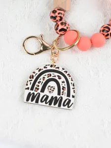 Detail of leopard print mama keychain with pink beads and gold clasp on white background