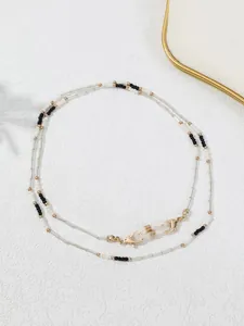 Detailansicht einer handgefertigten Perlenbrillenkette mit schwarz-weißen Perlen