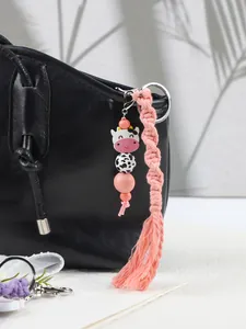 Handgefertigter rosa Makramee-Quasten-Schlüsselanhänger mit süßer Cartoon-Kuh-Silikonperle