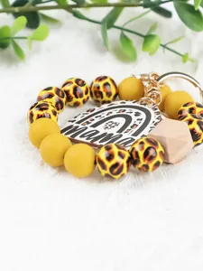 Macro detail of leopard print and yellow beads on a Mama rainbow keychain.