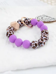 Close-up of leopard print and purple silicone bead keychain wristlet with Mama tag