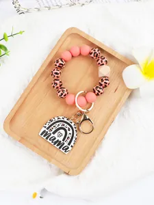 Close-up of leopard print and pink silicone beaded wristlet with mama rainbow charm