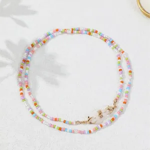 Cadena hecha a mano para gafas y mascarilla con cuentas de colores pastel y cierres dorados.