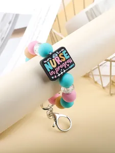 Close-up of silicone beaded keychain with NURSE in progress charm and metal clasp
