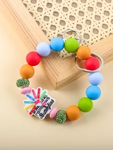Macro view of colorful silicone beaded keychain featuring a rainbows and butterflies charm.