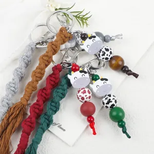 Portachiavi in macramé fatto a mano con ciondoli a forma di mucca e perle colorate