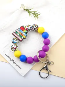 Detailed macro view of colorful silicone beaded keychain featuring school book charm