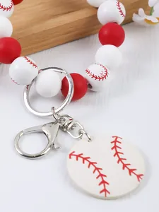 Detalle de un llavero de pulsera de cuentas de silicona de béisbol rojo y blanco.