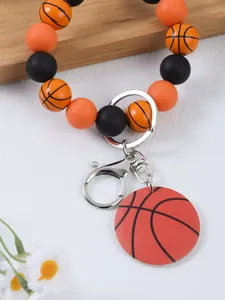Vista detallada del llavero de pulsera con cuentas de baloncesto y amuleto deportivo plata.