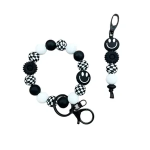 Schwarz-weißes Silikon-Perlenarmband mit Schachbrettmuster, Smiley und Blumenanhänger