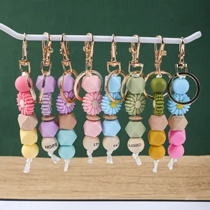 Vue détaillée de porte-clés en perles de silicone marguerite avec perles en bois.