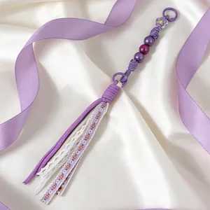 Detailed macro view of handmade purple beads and floral lace fabric tassel keychain