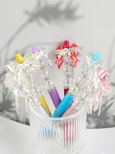 Close-up of decorative beaded pens with sparkling rhinestone bows and crystal accents