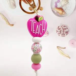 Handmade pink apple silicone bead keychain with 'TEACH' charm, perfect gift for teachers