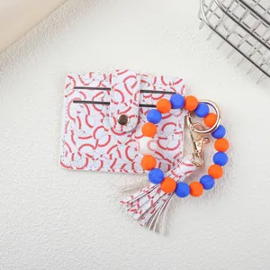 Detail view of baseball themed silicone bead bracelet and card holder set with tassel.