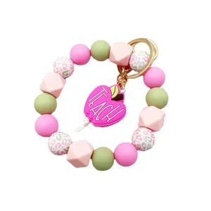 Colorful silicone beaded wristlet keychain with pink 'TEACH' apple charm for gift.