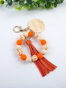 Detailed view of handmade silicone bead wristlet keychain with leather tassel and wood tag