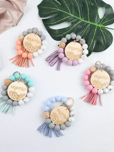 Colorful silicone and wooden beaded wristlet keychains with mama engraved charm and tassel.