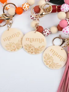 Close-up detail of silicone bead keychain with engraved mama wood disc and tassel
