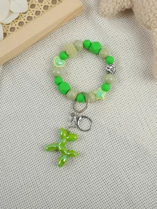 Detailed macro view of a green beaded keychain featuring a shiny metallic balloon dog pendant