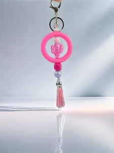 Detalle de un llavero de cactus de silicona rosa con cuentas hechas a mano y borla suave