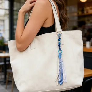 Handmade acrylic wooden bead and fabric tassel bag charm accessory on white tote bag