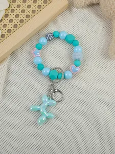 Macro detail of blue beaded bracelet keychain with pearlescent balloon dog charm