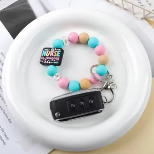 Cute colorful silicone beaded keychain with nurse in progress charm on a white plate
