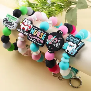 Colorful silicone beaded keychains with cute nursing and dental charms on display stand