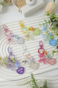 Close-up of colorful heart keychains with balloon dog and 'LOVE YA' charms