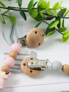 Detalle de un sujetachupetes de madera DIY con cuentas de silicona de colores y mordedor.
