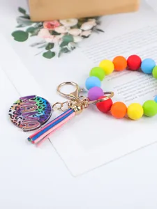 Close-up detail of colorful silicone bead wristlet featuring a leopard MAMA charm and tassel