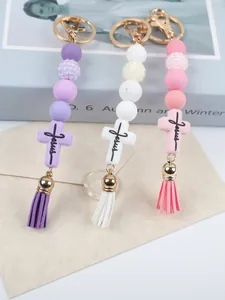 Detailed view of silicone beaded keychains with Jesus cross and tassels in three colors.