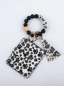 Detail view of silicone bead bracelet keychain with paw print card holder and tassel