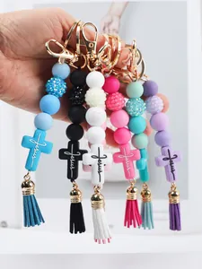 Close-up of colorful silicone bead keychains with Jesus cross pendant and tassels