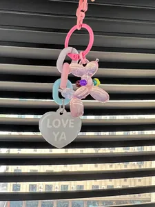 Close-up detail of a colorful rainbow chain keychain with balloon dog and heart charm.