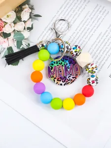 Close-up of a colorful silicone bead wristlet with MAMA leopard charm and black tassel