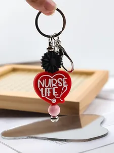 Detailed macro view of red heart silicone keychain with Nurse Life text and daisy bead