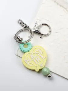 Detailed view of yellow silicone heart keychain with Nurse Life text and mint daisy