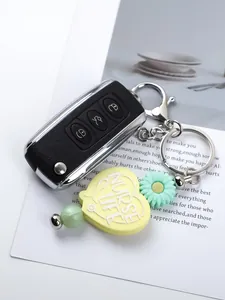 Close-up of a cute yellow silicone heart keychain with Nurse Life text and daisy charm
