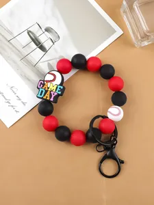 Detalle de una pulsera llavero de cuentas de silicona con dije de béisbol y texto.