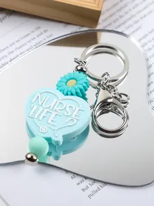Close-up of 'Nurse Life' silicone heart keychain with daisy and mint green bead details.