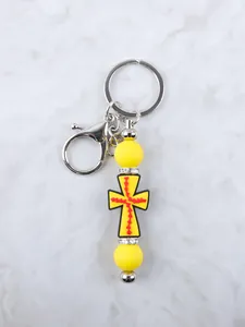 Llavero de cruz de silicona amarilla con cuentas de strass y cierre de langosta vista detallada