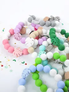 Detailed view of colorful silicone beaded keychains with monstera leaf charms