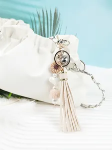 Détail d'un porte-clés à pompon fait main avec marguerite en silicone et pompon rose