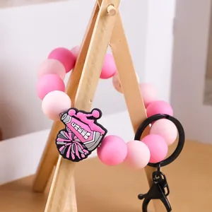 Pulsera llavero creativa de cuentas de silicona rosa con amuleto de animadora y aro de metal
