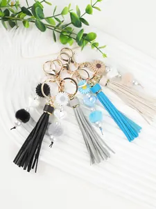Porte-clés à pompons faits main avec marguerites, pompons et perles en forme de cœur.