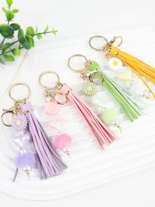 Vue détaillée de porte-clés à pompons colorés faits main avec marguerites en silicone et boules